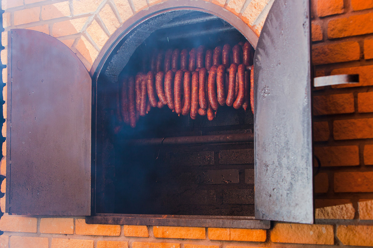 Klobásy zavesené vnútri domácej udiarne